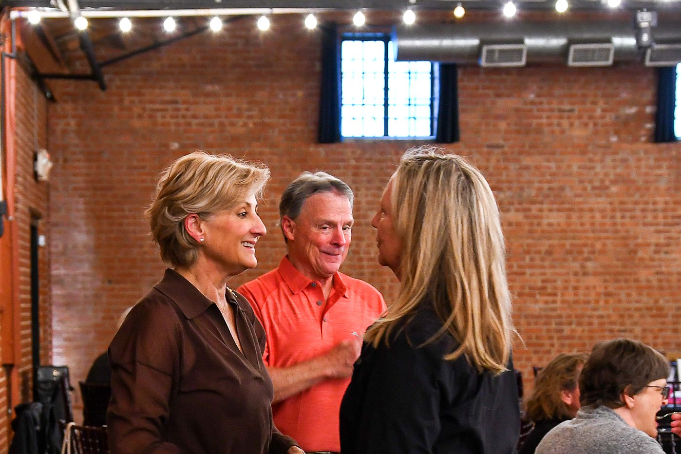 Three guests in conversation at the firm's 2026 annual client meeting