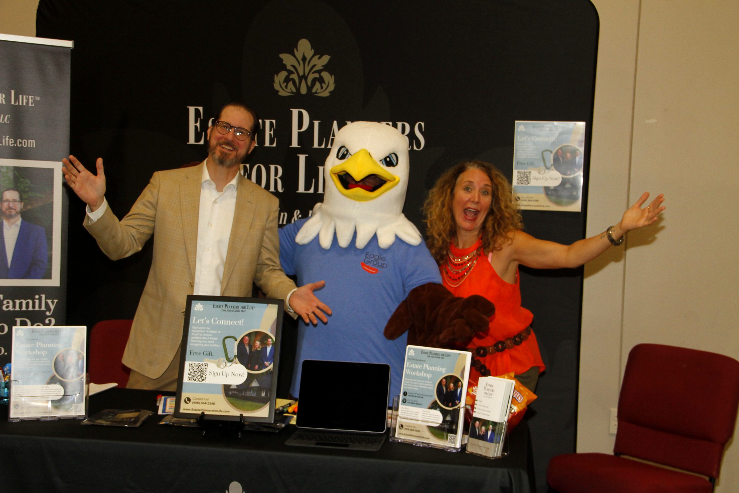Mitch Janik and a member of the team with the expo's eagle mascot behind the firm's booth
