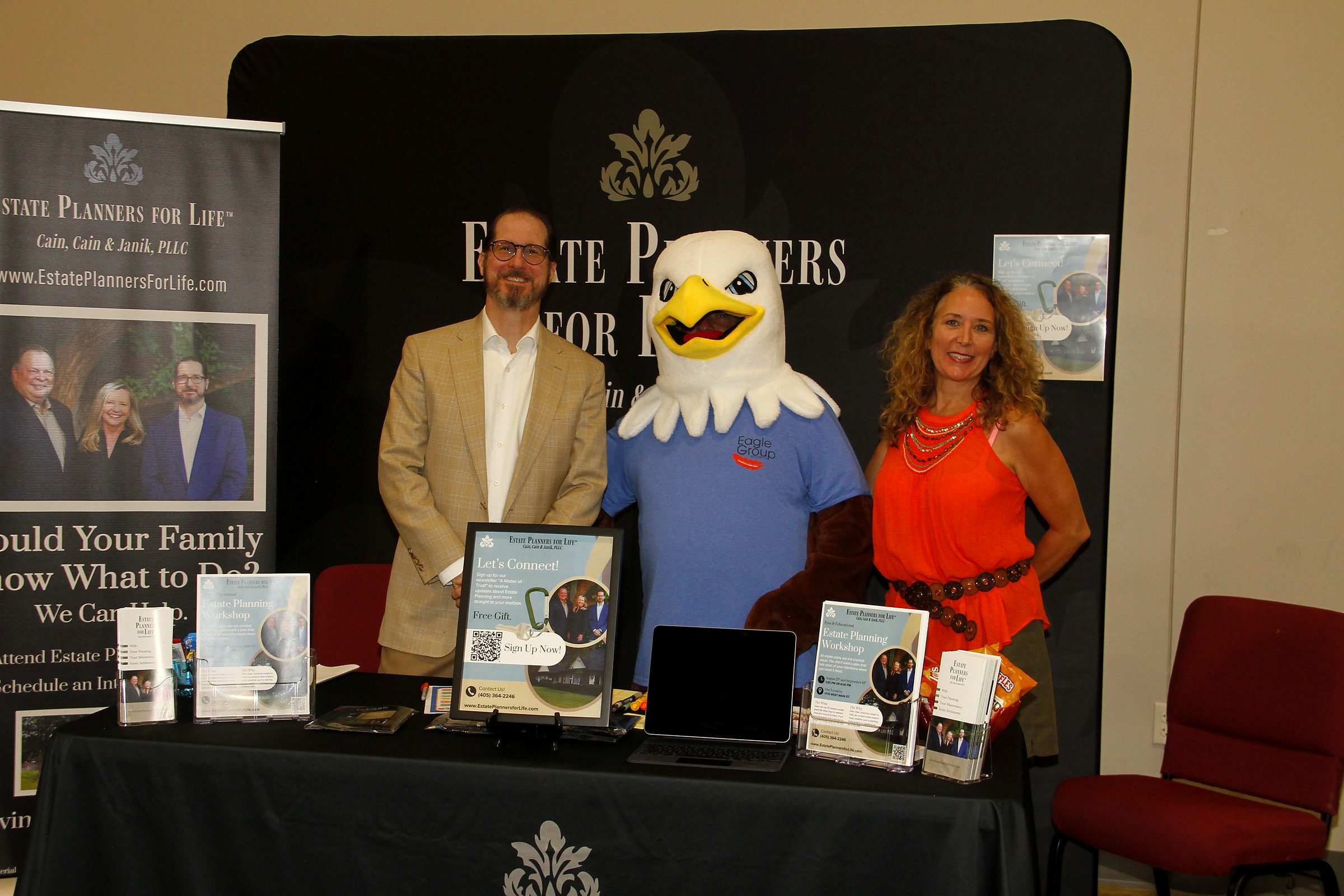 Mitch Janik and a member of the team either side of the expo's eagle mascot at the firm's booth