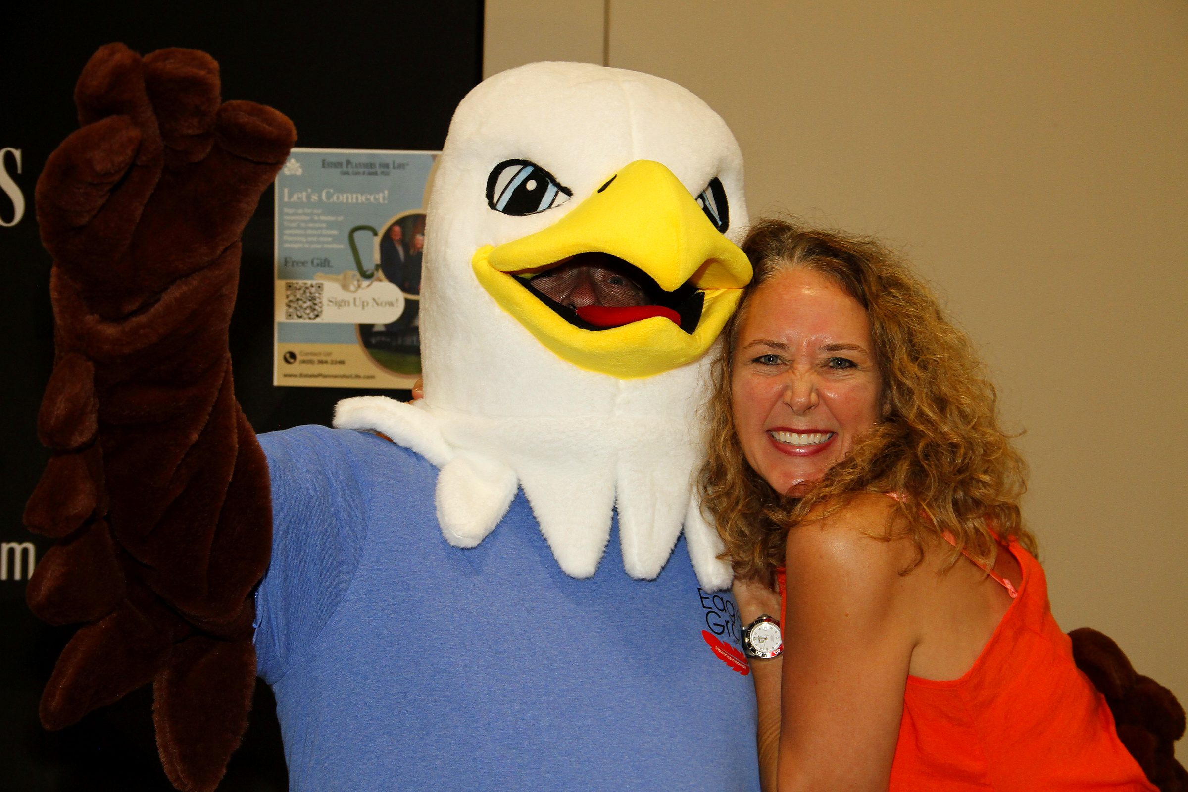 A member of the team with the expo's eagle mascot at a community senior expo