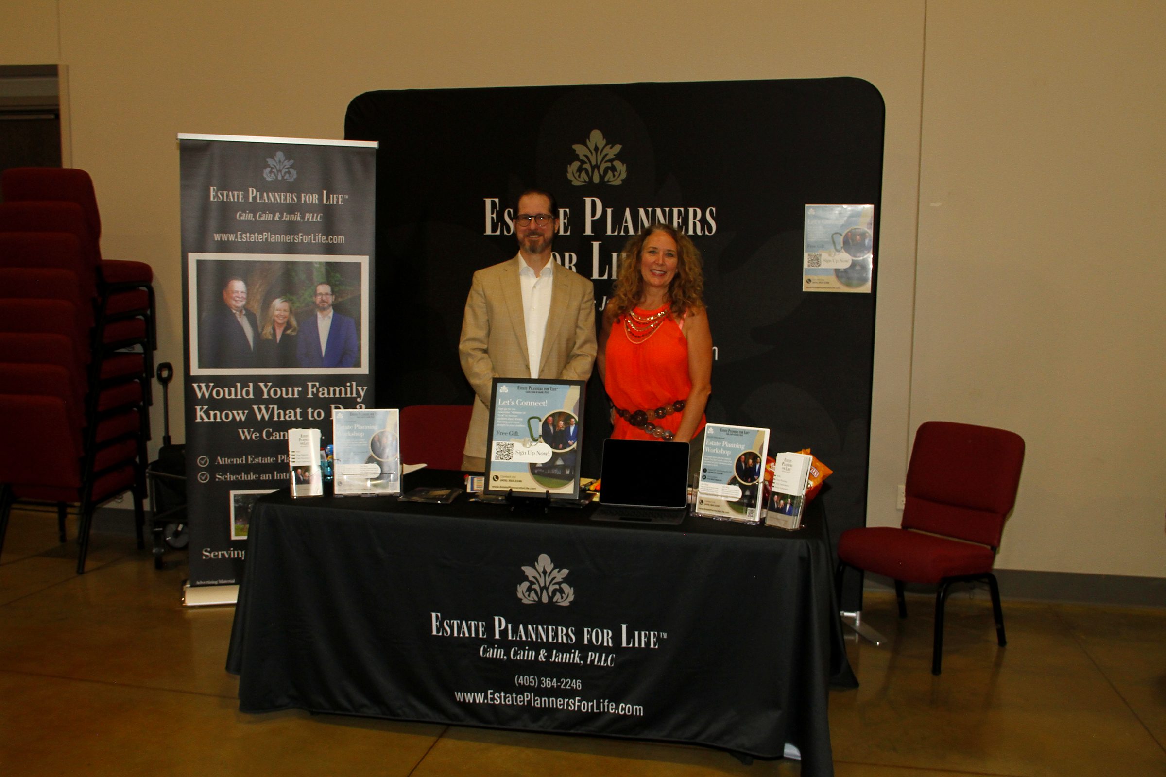 The Estate Planners for Life booth at a community expo, Mitch Janik and a member of the team behind the table